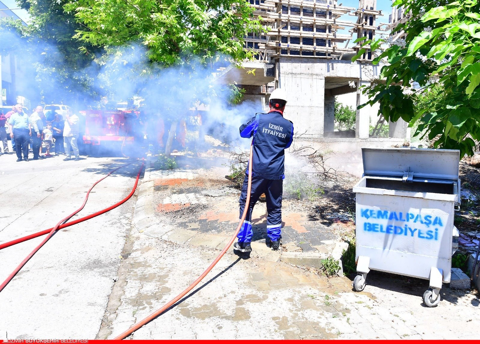 Yukarıkızılca’daki yangın tatbikatında kuru dallara su sıkan İzmir İtfaiyesi görevlisi